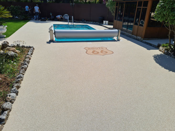 Pose de la moquette de pierre sur une plage de piscine des équipes Résilux