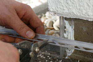 Pose de baguettes en aluminium pour délimiter la zone d'application de la moquette de pierre