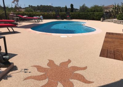 exemple de motif soleil pour une plage de piscine en moquette de pierre